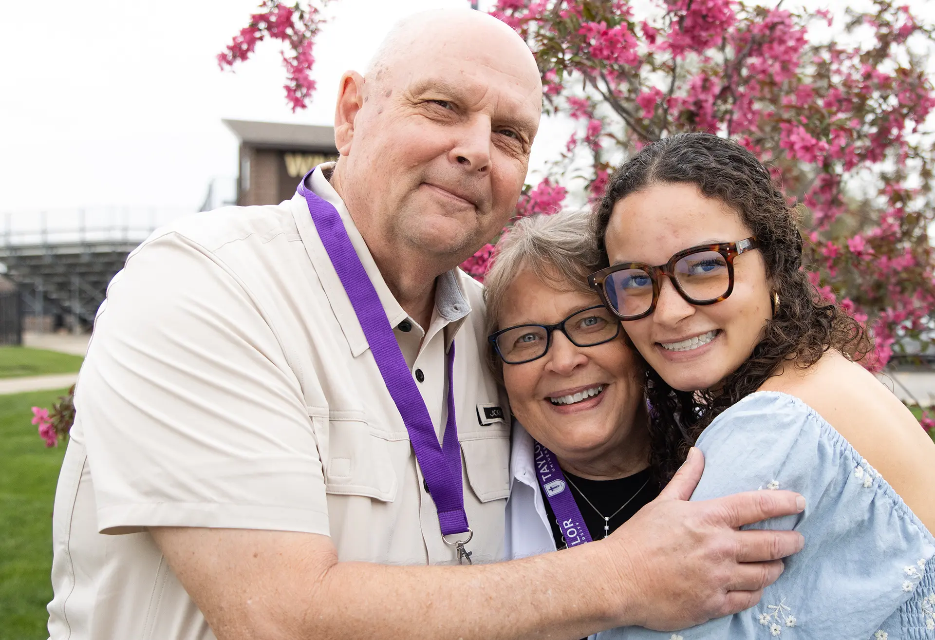 Grandparents hugging their grandchild at Grandparent's Day