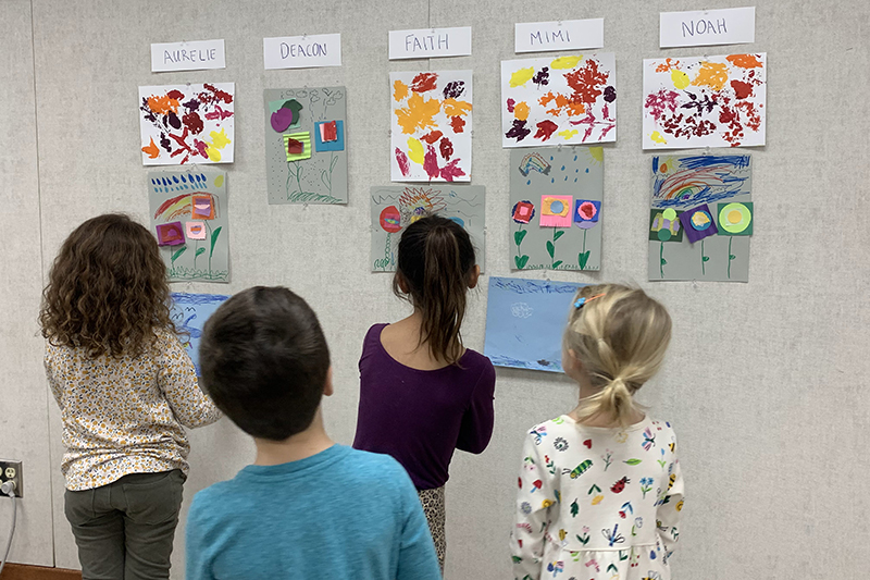 kids showing art created during art tutoring