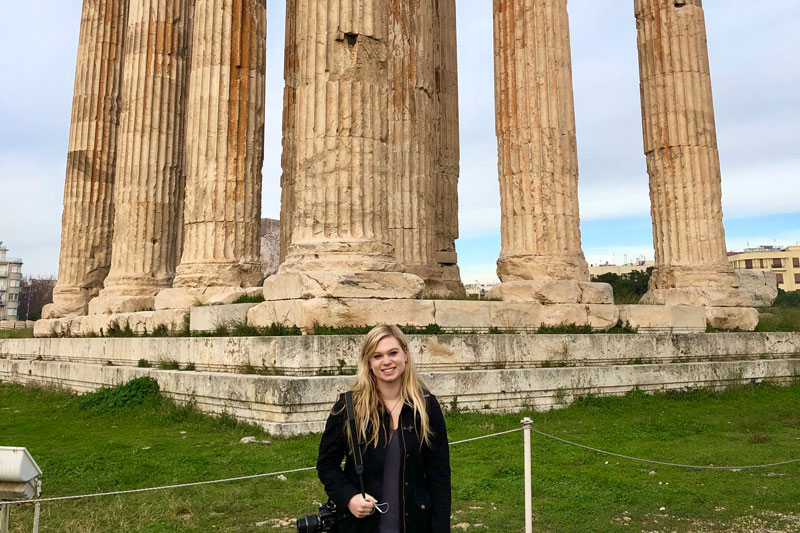 Grace Allan in front of ancient pillars