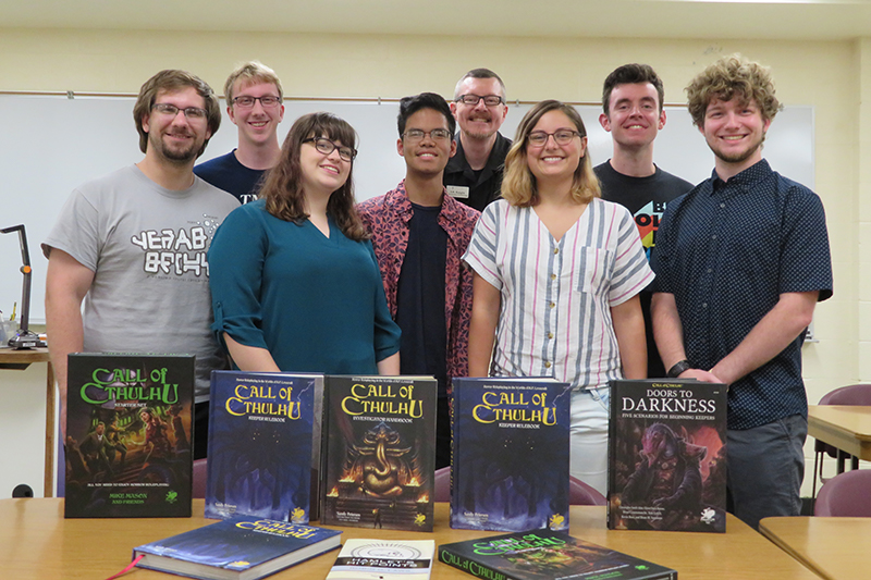 Taylor students posing in front of RPG books