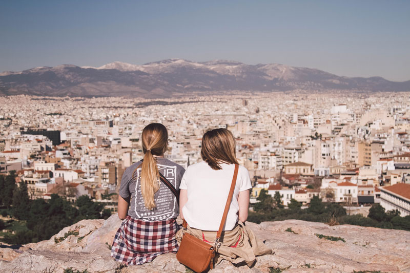 Pair of students looking over a Greek landscape