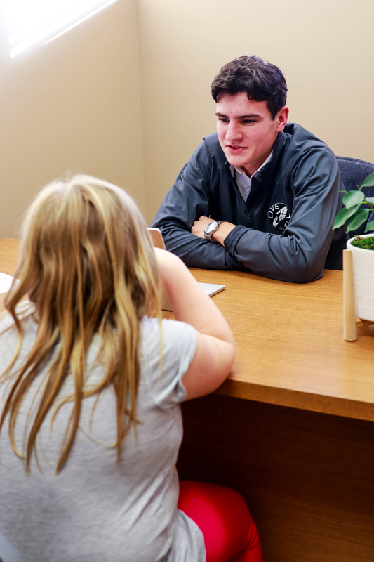student talking to a client in invitation program