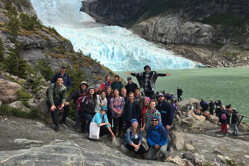 A group posing in front of a frozen waterfall