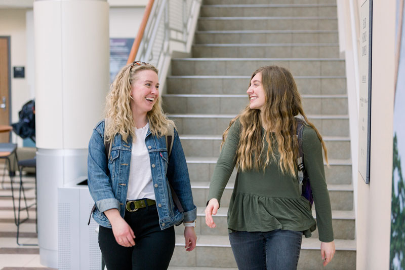 Two female students walking down the stairs in Euler Atrium