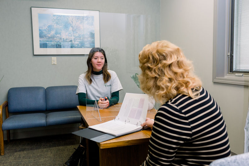 Student talking to a client in the Invitation Program
