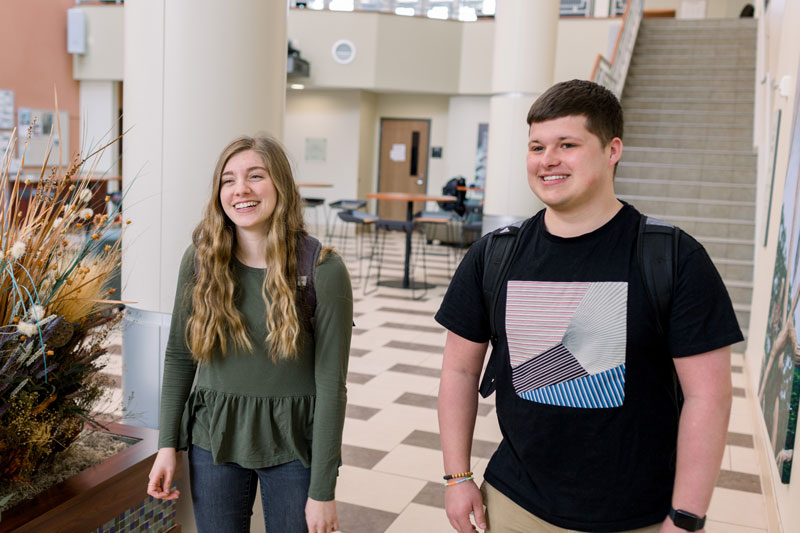 Two students smiling and standing in Euler Atrium