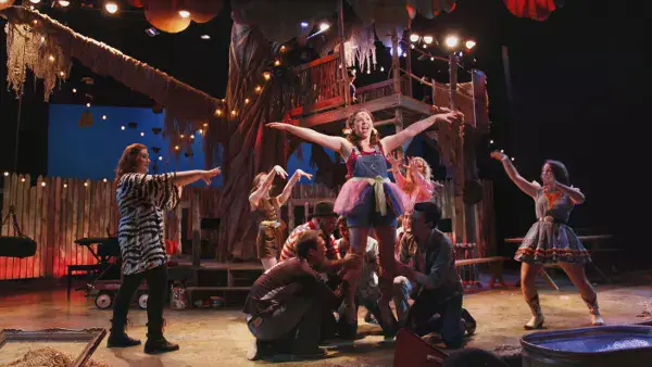 A group lifting an actress in Godspell