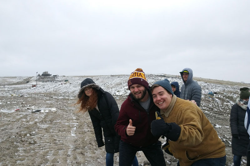 Students giving thumbs up in a snowy field