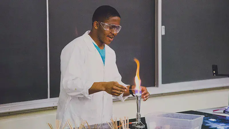 Taylor student holding something over an open flame