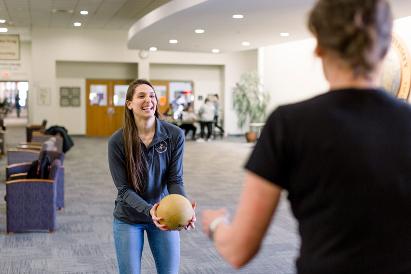 A student throwing a weighted therapy ball
