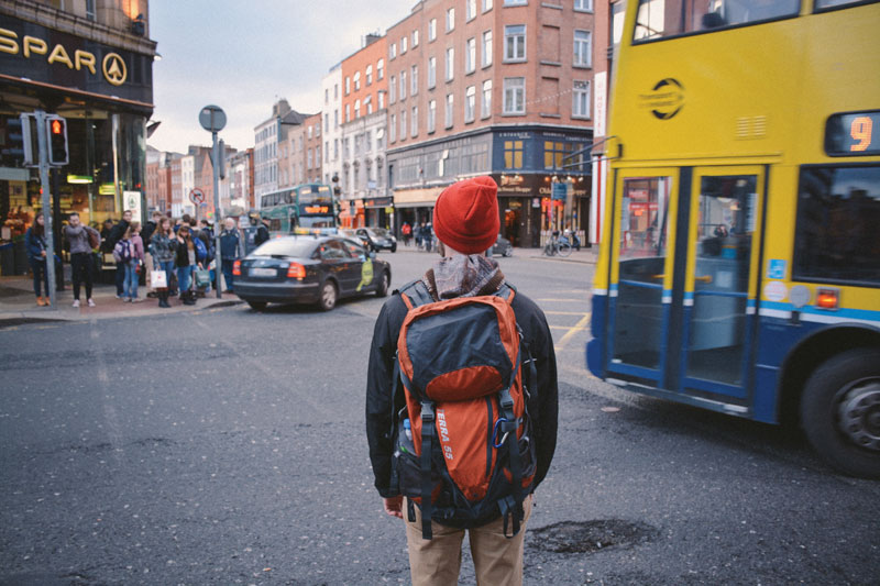A student standing on a busy street corner