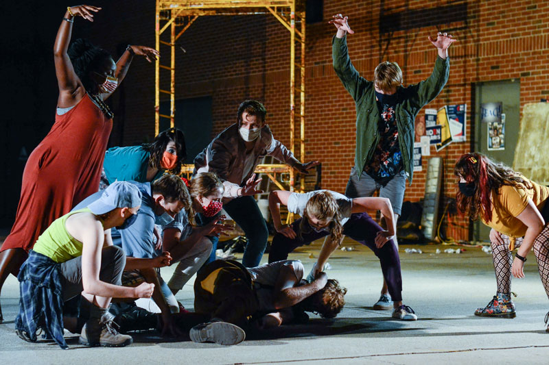 A group tormenting a man on the ground in Godspell