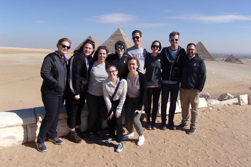 A group of students posing in front of the Pyramids of Giza