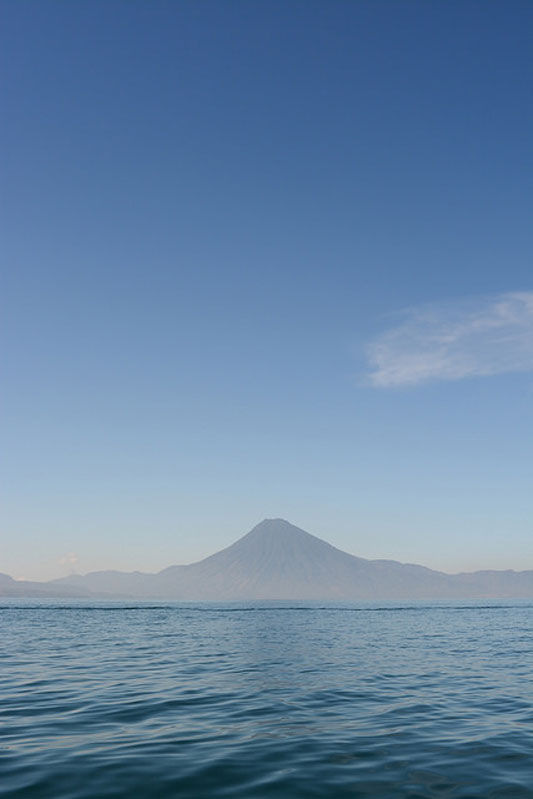 An open ocean with a misty mountain in the distance