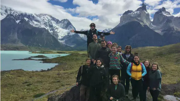 Taylor students standing on a hill overlooking a lake, plains, and mountains