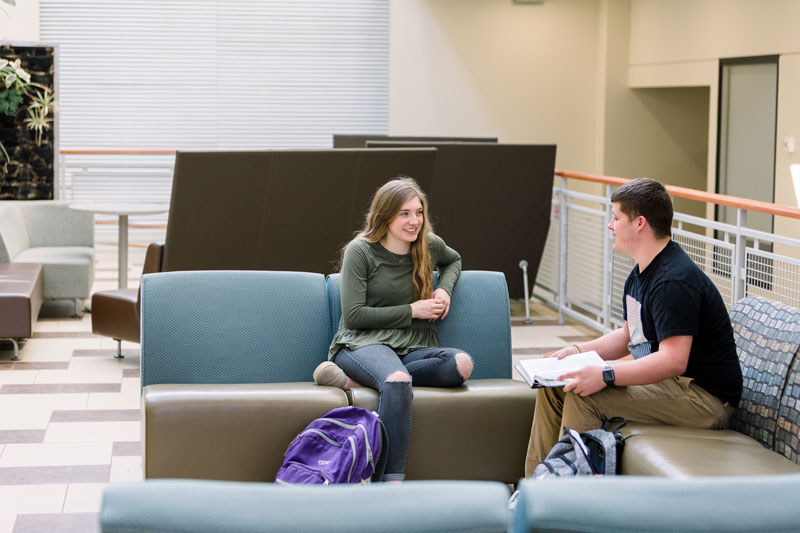 Two students talking and studying in Euler Atrium