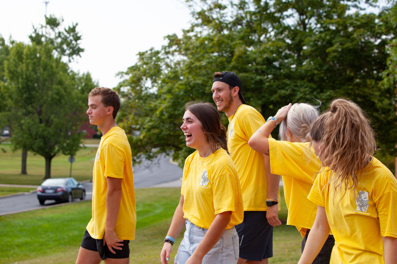 A group of students in yellow shirts laughing