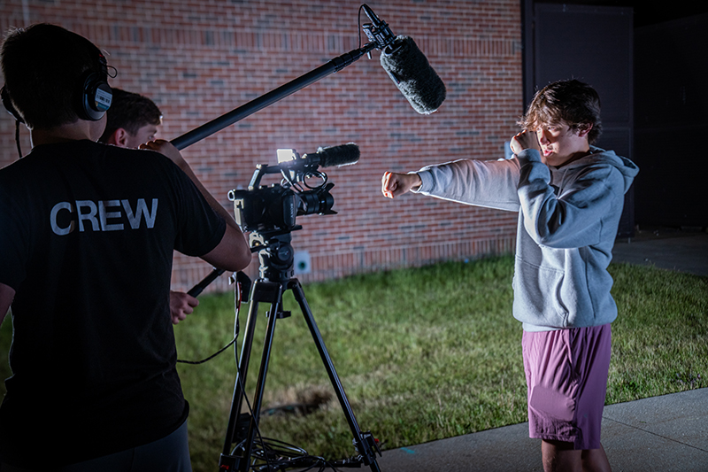 student recording an actor posing
