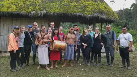 Taylor students gathered with locals holding instruments and dressed in traditional clothes