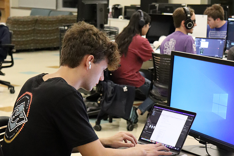student works on programming a computer game