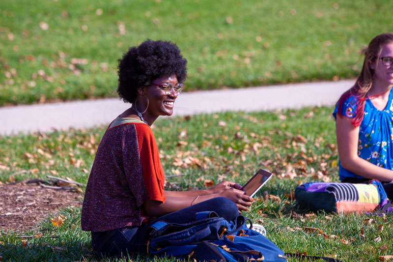 A student sitting outside with her laptop