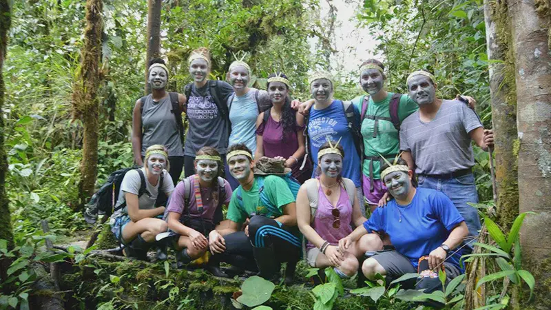 Group of students in the forest with blue facepaint and leaf circlets