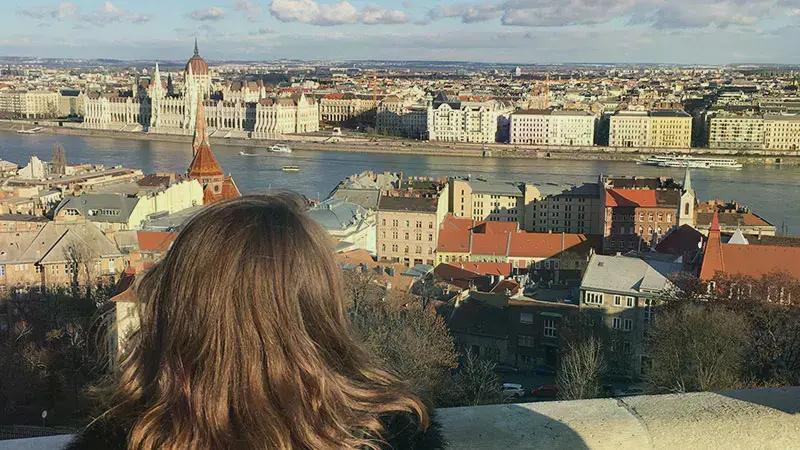 Female student looking at a river in Hungary