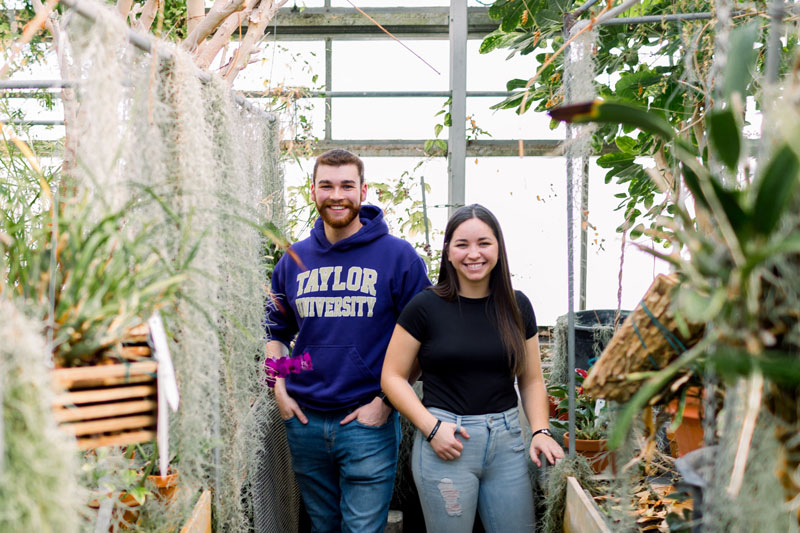Two students standing in the Nussbaum Greenhouse