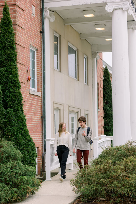 two students walking past an academic building