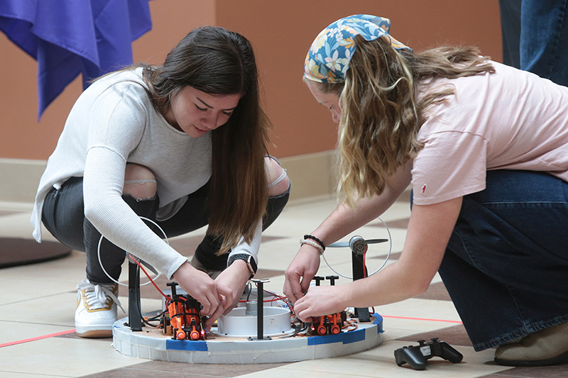 Two students work on their battle bots