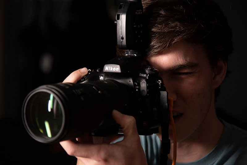 A student holding a Nikon camera