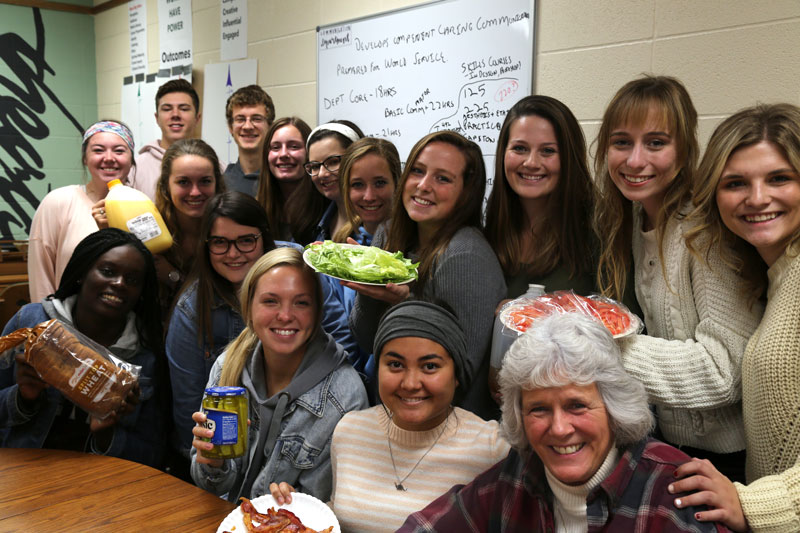 A group of students holding food products in a classroom