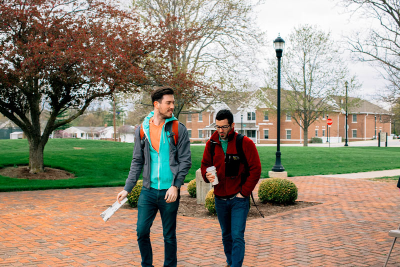 Two students conversing and walking to class