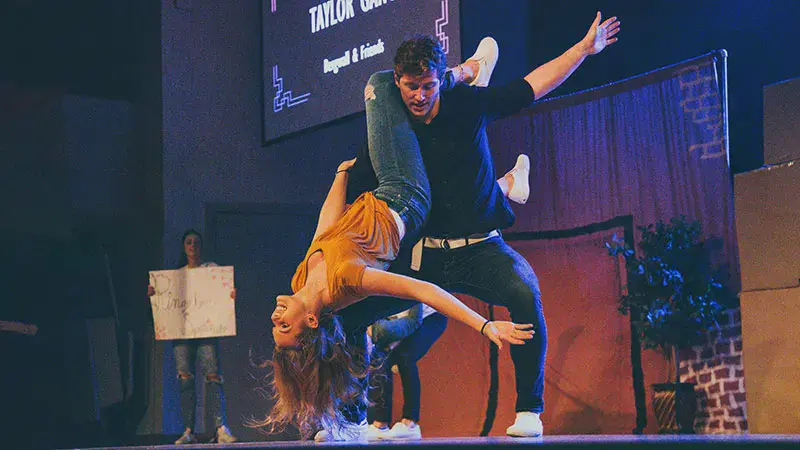A male student flipping a female student at Airband