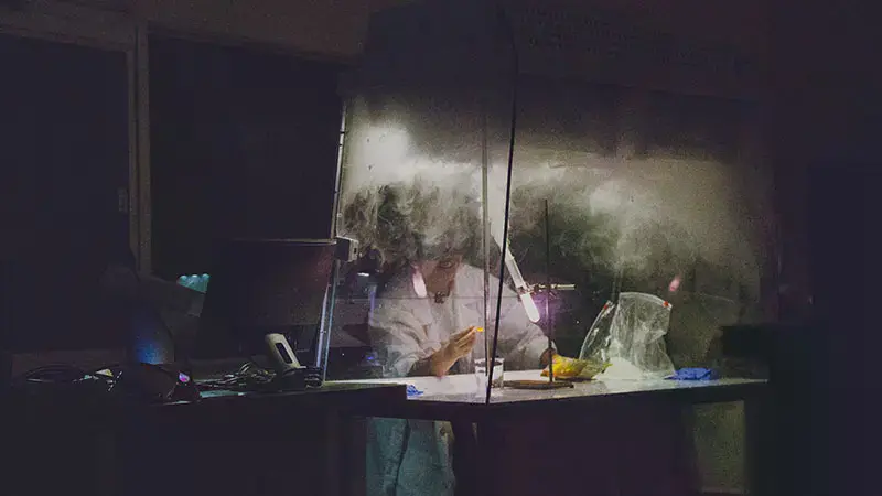 A student showing the fumes coming off of a chemical by turning off the lights
