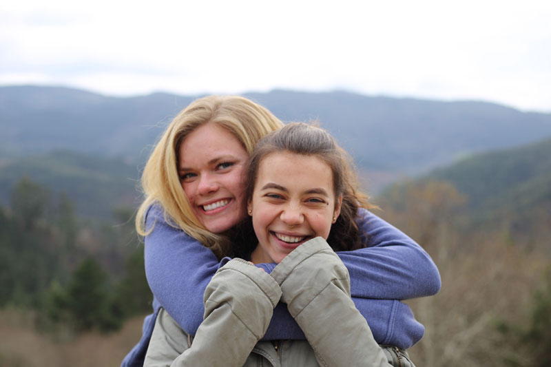 Two students hugging in the mountains