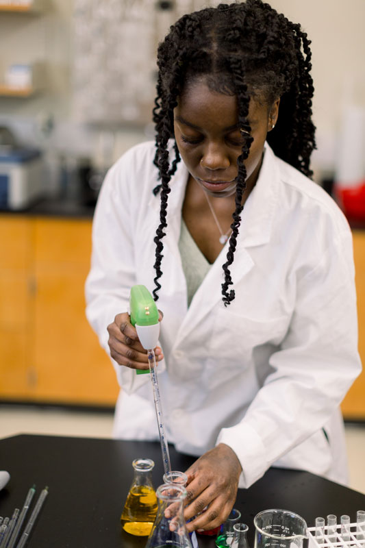 female student using biology lab equipment