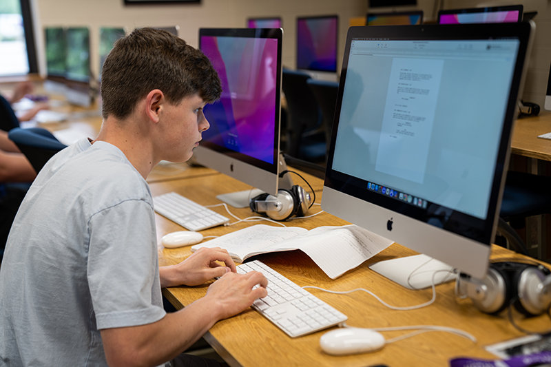 student writing a script in the mac lab