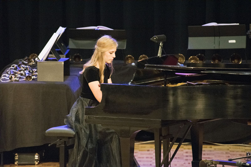 A student performing a piece on a grand piano