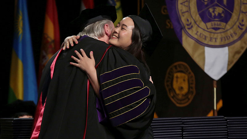 Haines hugging a graduate