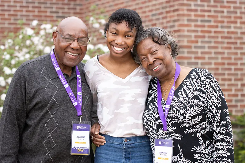 girl poses with her grandparents