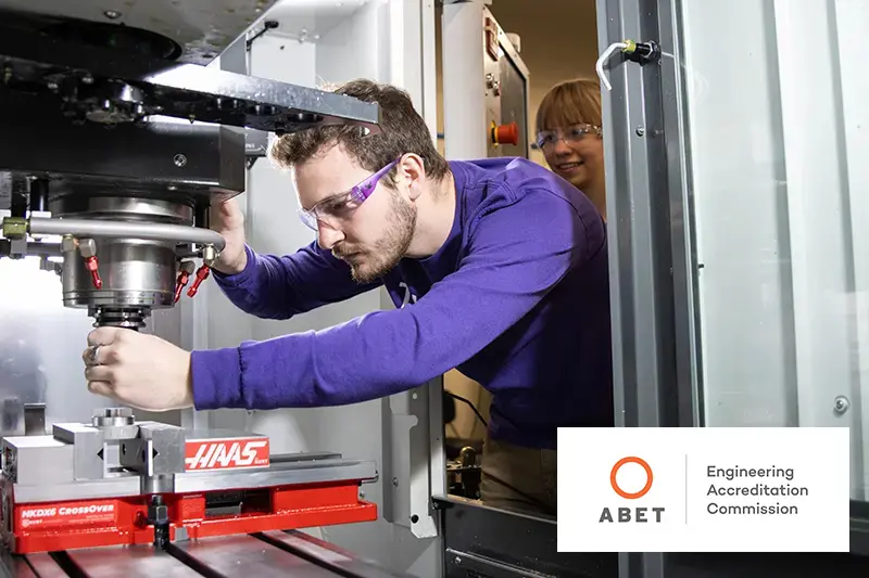 male student working with CNC machine