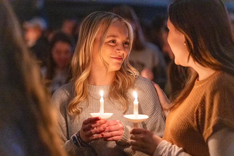 Girls smiling and holding candles