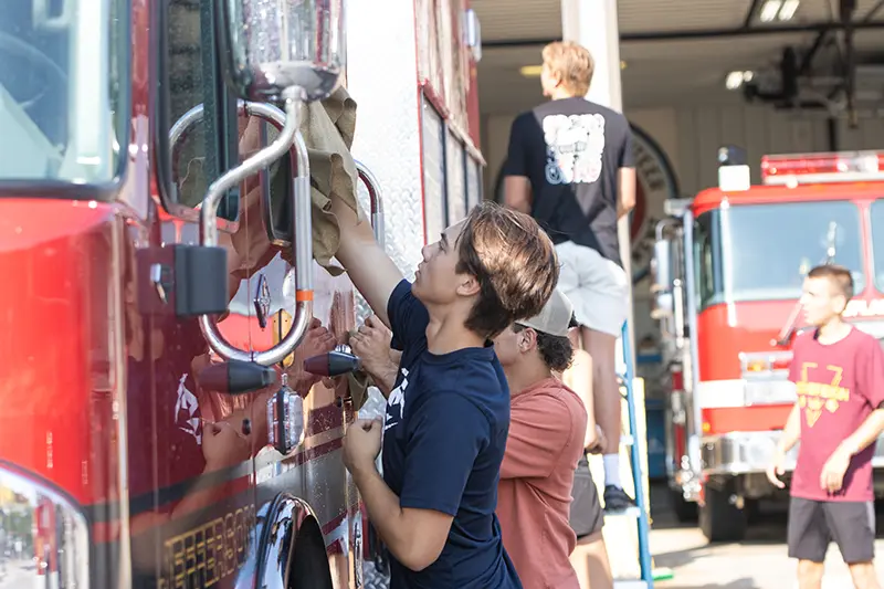 Students wash a fire truck
