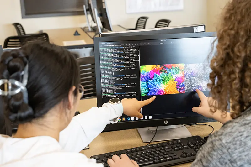 two students on computer pointing