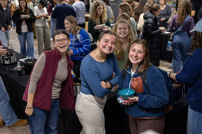 girl students smile at empty bowls
