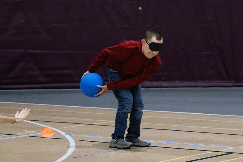 Student Nate Taylor rolls the goalball
