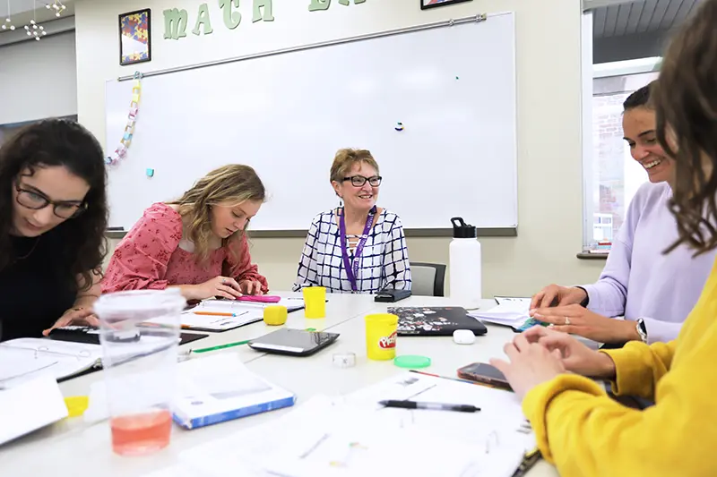 students at a table in classroom with with play-doh