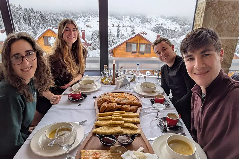 Kosovo team at breakfast with mountains in background 