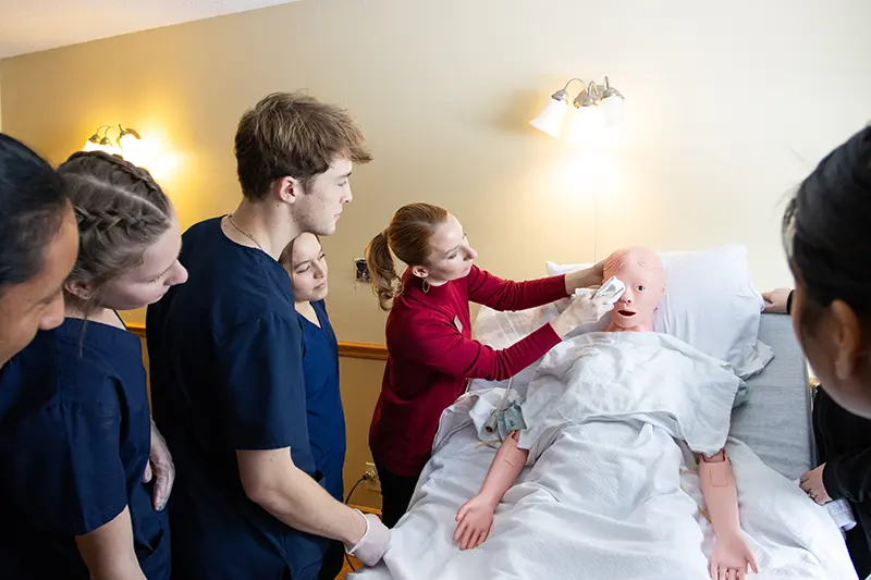 CNA students work with manequin